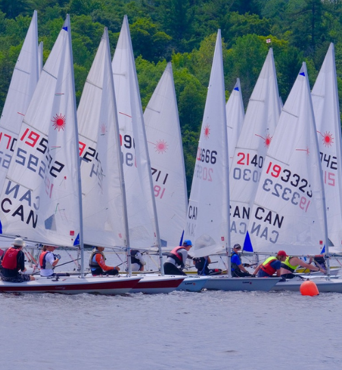 This is a photo of many dinghy sailboats at the start line in a race