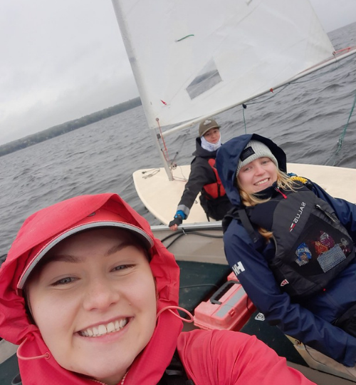 This is a photo of three youth racing in sailboats